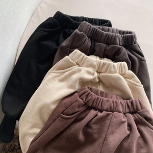 Détail des tailles élastiques en coton épais et des poches latérales sur les pantalons enfant