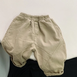 Detail of kids khaki twill pants with elastic waist and rolled hem in casual Korean style