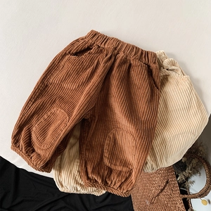 Close-up of kids corduroy pants with elastic waist and knee patches in brown and cream
