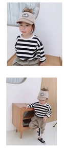 Close-up of girls' black and white striped cotton long sleeve tee with khaki pom-pom cap