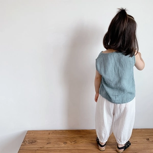 Vista posteriore di un bambino con canotta verde e pantaloni di lino bianchi