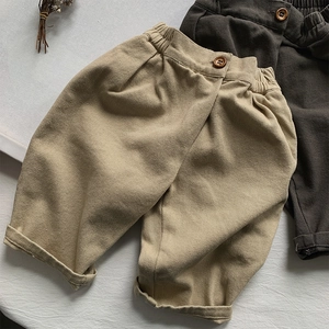 Detail of khaki and coffee loose cotton pants with elastic waist and wooden buttons