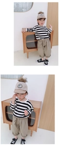 Detailed view of girls striped long sleeve tee with khaki cargo pants and a pompom cap