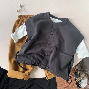 Flat lay of a stylish dark gray cotton vest with mustard yellow elastic waist pants