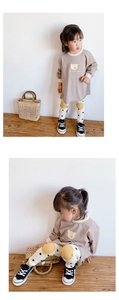 Detail of toddler autumn set featuring brown bear sweatshirt and white polka dot trousers