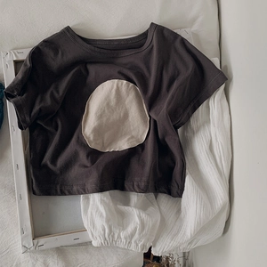 Mise à plat d'un t-shirt en coton gris foncé et d'un pantalon en gaze blanc enfant