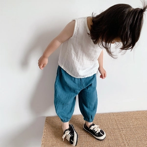 Modello bambino asiatico con gilet di cotone senza maniche bianco e pantaloni harem blu
