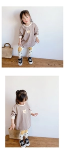 Detail of baby girl outfit with brown bear sweatshirt and white polka dot leggings