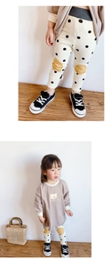 Detail of baby girls' polka dot leggings with yellow knee patches and cotton fabric texture