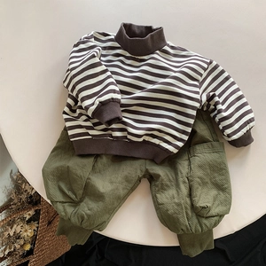 Details von Kinder-Rollkragenpullover und olivgrüner Cargo-Hose im Set auf Tisch