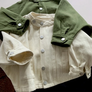 Détail d'une veste en sergé de coton avec boutons-pression en métal et grandes poches