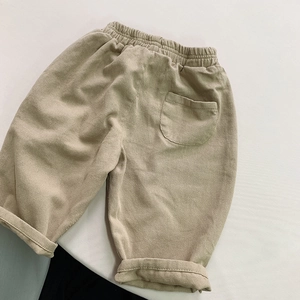 Detail of khaki corduroy children's pants with elastic waist and back pocket feature