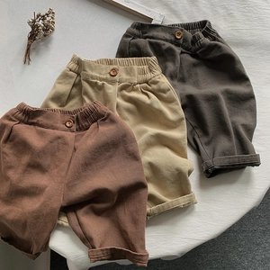Close-up of three colors of thick cotton toddler pants with elastic waist and wood buttons