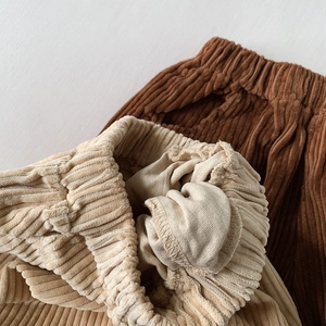 Detail of warm corduroy pants with elastic waist and soft fleece lining for kids