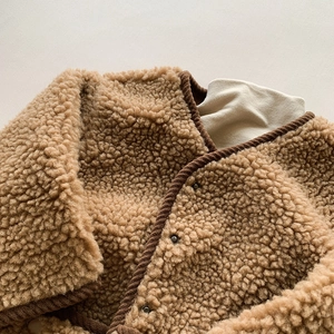 Gros plan détaillé du gilet en polaire marron pour enfant avec bordure en velours côtelé