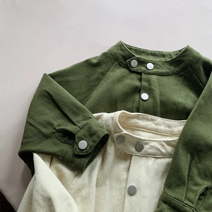 Gros plan d'une veste en coton pour enfants olive et beige avec boutons-pression