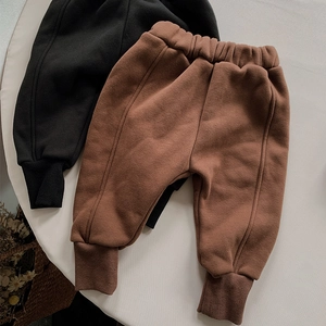 Flat lay of thick fleece-lined kids joggers in black and brown with ribbed cuffs