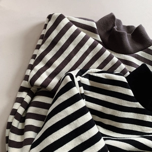 Close-up of striped polar fleece sweaters with high-ribbed necklines and soft textures