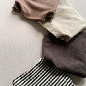 Flat lay of soft thermal base layers for kids in earth tones and stripes