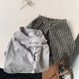 Gros plan du pantalon large à rayures en coton et lin avec boutons décoratifs