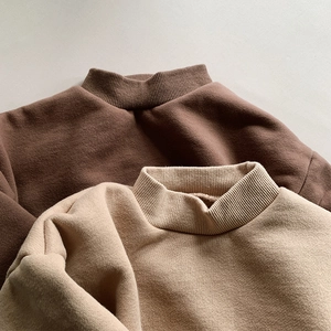 Detail of high-neck ribbed collar on thick fleece sweatshirts in brown and apricot yellow