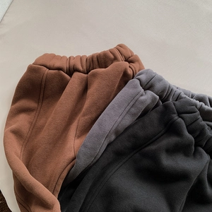 Detail of fleece-lined thermal pants for children in brown, dark grey and black colors