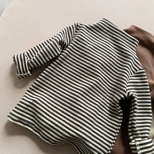 Detail of children's mock neck thermal top featuring classic black and white stripes