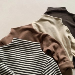 Detail of four warm thermal high-neck tops for kids in striped and solid neutral colors