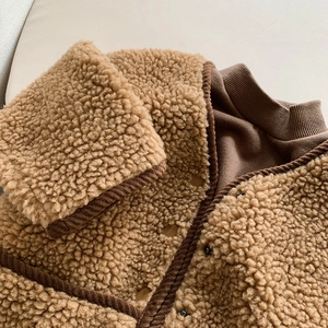 Vue détaillée du gilet en peau lainée marron avec bordure en velours et boutons texturés