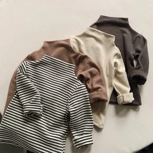Flat lay of soft thermal base layers for kids in earth tones and striped patterns
