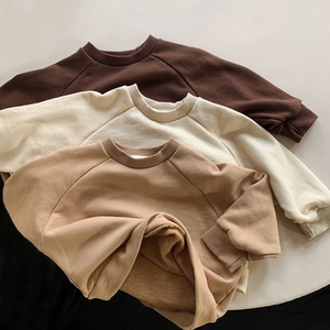 Detail of ribbed cuffs and soft fleece lining on kids cotton sweatshirts in earth tones