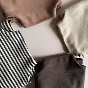 Flat lay of soft thermal base layers for children in neutral colors and striped patterns