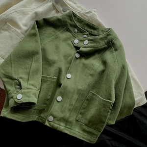 Détail de la veste enfant minimaliste avec boutons-pression et grandes poches