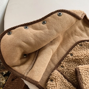 Détail de la veste en polaire pour enfant avec bordure en velours et boutons pression