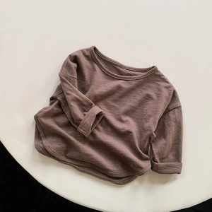 Detail view of cotton long sleeve tee with slub texture, rolled cuffs and curved hemline
