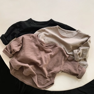 Detail view of cotton long-sleeve kids T-shirts showing rolled cuffs and curved hem details