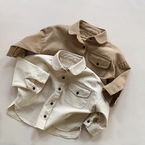 Flat lay of khaki and cream cotton long sleeve shirts for kids with double chest pockets