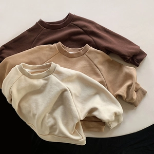Detailed flat lay of three kids' cotton sweatshirts in brown, camel, and cream tones