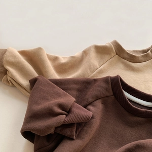 Detail of cotton kids sweatshirt showing ribbed crewneck and raglan sleeves texture