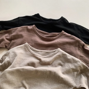 Detail of three long-sleeved slub cotton t-shirts in black, brown and beige colors