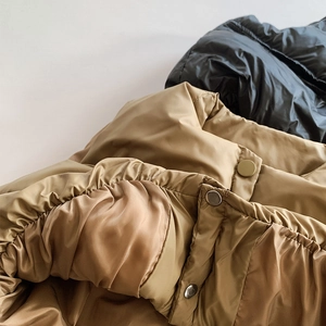 Détail des boutons-pression métalliques et des bords élastiques du gilet enfant