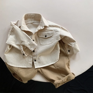 Flat lay of cream button-down utility shirt paired with khaki casual cotton trousers for kids