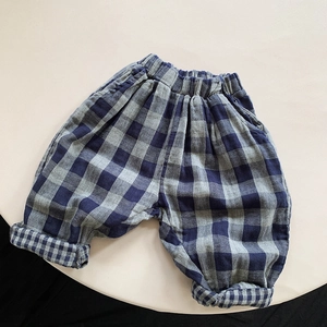 Detail of blue gingham cotton trousers for kids showing elastic waist and folded cuffs