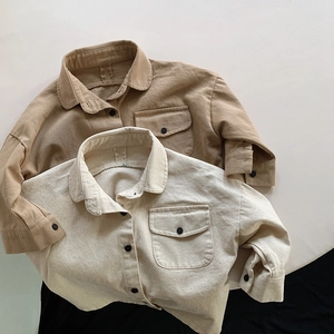 Close-up of khaki and beige cotton shirts for kids featuring chest pockets and classic collars