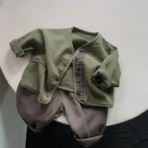 Flat lay of green waffle knit cardigan and brown loose cotton pants for kids