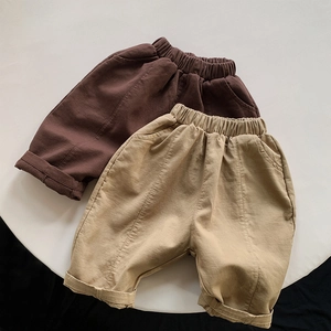 Flat lay of brown and khaki kids loose canvas pants with elastic waist and cuffed hems