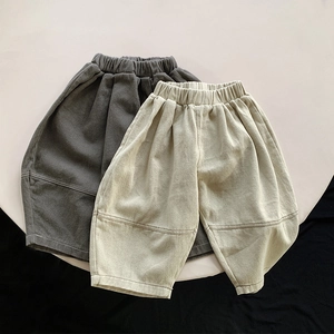 Close-up of kids loose harem pants in dark grey and beige with elastic waist detail