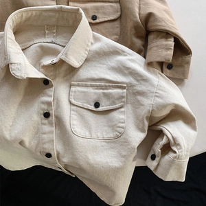 Detailed macro view of heavy washed cotton kids shirt showing vintage canvas texture