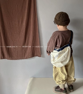 Kids long sleeve slub cotton tee with mustard corduroy pants and a beige canvas bag