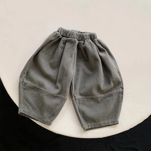 Detail of loose dark grey cotton harem pants for kids featuring an elastic waistband